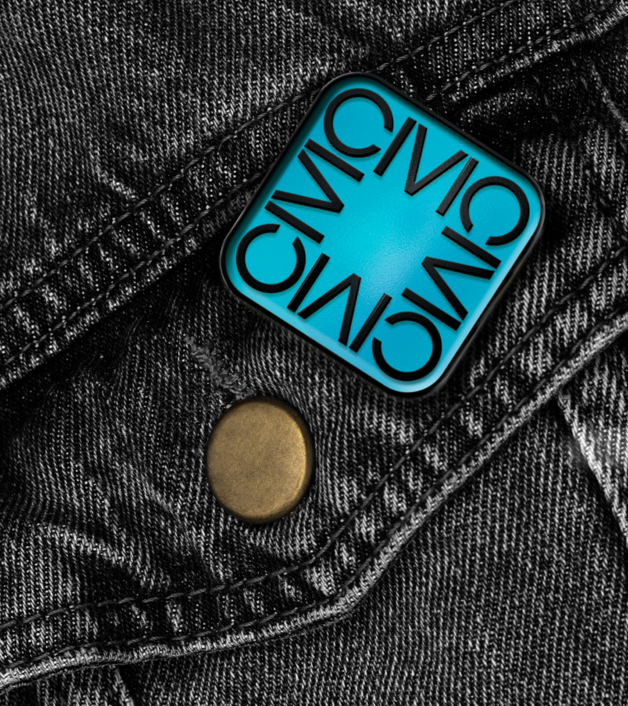 An enamel pin of the Civic News Company symbol