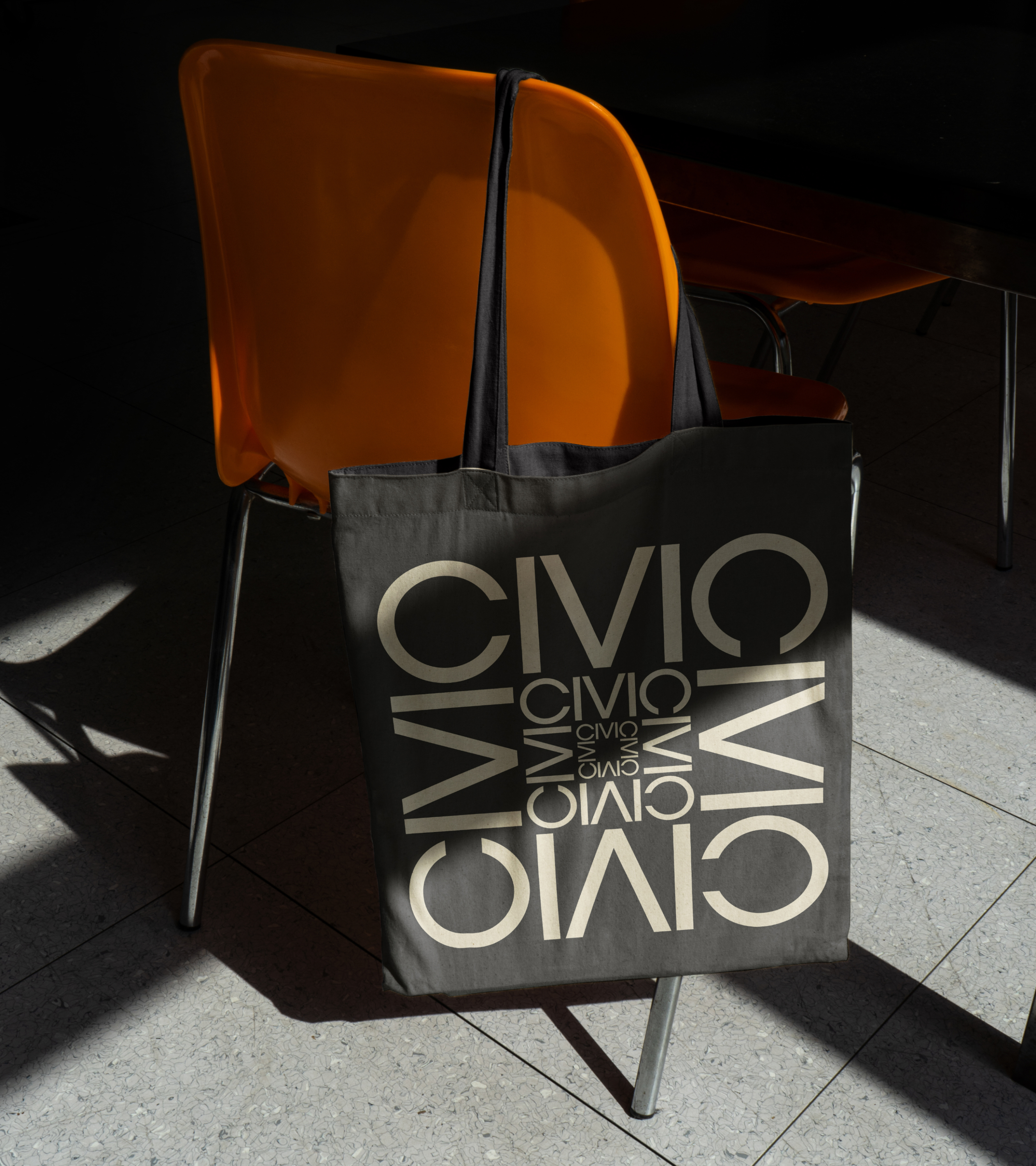 An image of a branded tote bag hanging from a chair