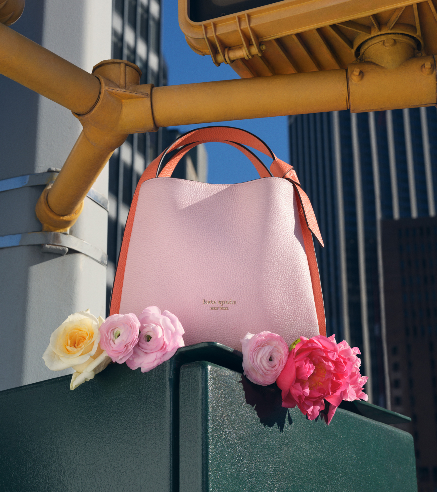 a Kate Spade Spring 2024 Knott Bag with a few spring flowers